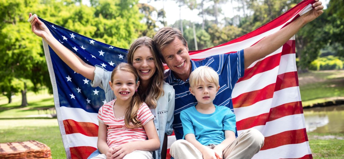 Man with American flag wrapped around his family