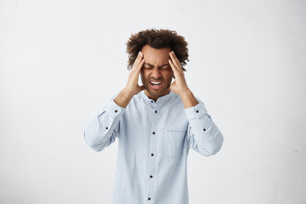 guy holding his head with headache