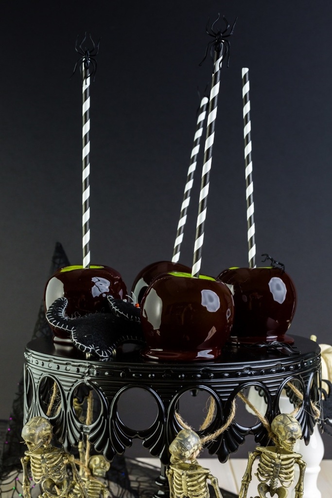 Black candy apples on a black halloween cake stand