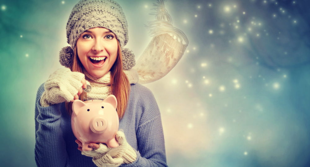 Happy young woman depositing money into her piggy bank